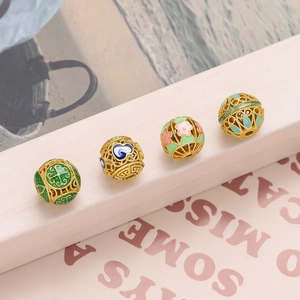 Detailed macro of gold hollow beads with colorful enamel patterns for DIY jewelry