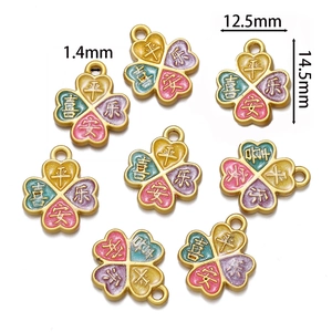 Détail du pendentif trèfle à quatre feuilles avec finition dorée et pétales émaillés