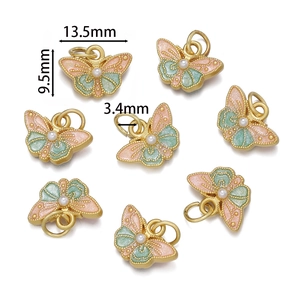Détail du pendentif papillon doré 13,5mm avec émail rose et perle imitation