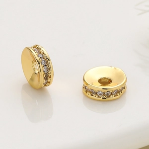 Vue macro de perles d'espacement dorées 18k serties de zircons pour bijoux artisanaux