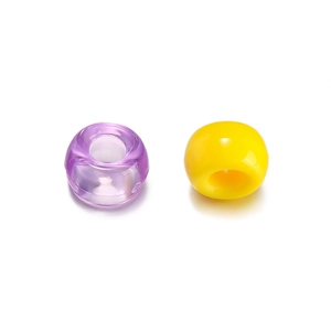 Close-up of colorful acrylic large-hole beads in transparent purple and opaque yellow