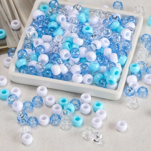Assorted candy-colored acrylic big hole barrel beads in a white ceramic dish for DIY jewelry