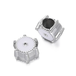 Detailed macro view of silver CCB beads with white enamel finish and inset zircon stones