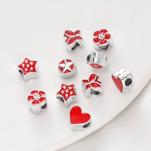 Close-up of red enamel heart and star charms for DIY bracelet bead sets