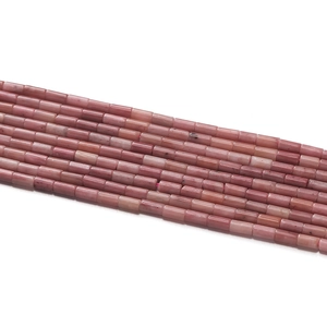 Texture détaillée de perles cylindriques en pierre naturelle rose pour bijoux