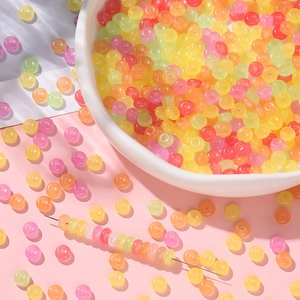 Bunte transluzente Glasperlen für DIY-Schmuck in einer dekorativen weißen Porzellanschale