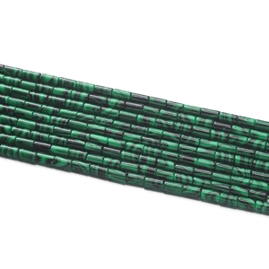 Vue macro de perles cylindriques en malachite montrant une texture rayée verte pour DIY