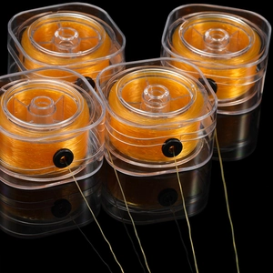 Detail von vier orangefarbenen elastischen Schmuckfäden in Boxen mit Gummi-Auslassöffnungen