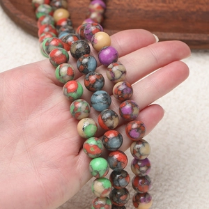 Bunte böhmische 10mm Rundperlen mit Netzmuster-Textur in der Hand für DIY-Schmuck