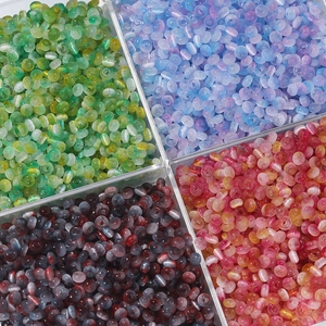 Makroaufnahme von 2x4mm Katzenaugen-Glasperlen in Grün, Blau und Rot für DIY Schmuck