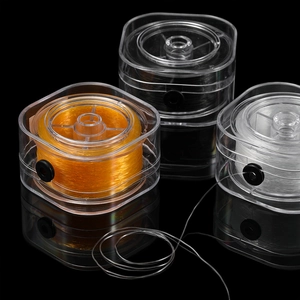Drei farbige elastische Perlenschnüre in transparenten Boxen mit Gummi-Auslassöffnung
