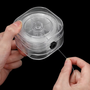 Detailansicht der elastischen Perlenschnur in einer Box mit Gummi-Fadenauslass