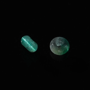 Makro-Detail grüner Katzenaugen-Glasperlen mit seidigem Glanz und Faserstruktur