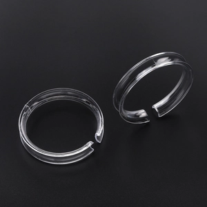 Macro detail of clear C-shaped acrylic display rings for bracelets and jewelry beads