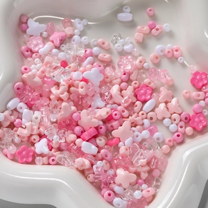 Mixed acrylic beads in pink and white hues, featuring flower, star, and bow shapes for DIY