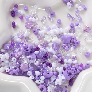 Assorted lavender and purple acrylic DIY beads in floral and bow shapes on a star tray