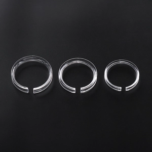 Three clear acrylic display rings for bracelets in graduated sizes on a black background