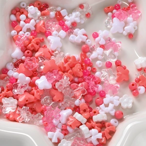 Macro view of assorted pink and white acrylic beads for DIY jewelry making in a star tray