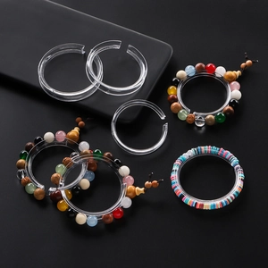 Clear acrylic bracelet display ring and C-clip stand on dark background