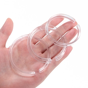 Three clear acrylic display rings for bracelets shown in hand on white background