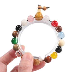 Acrylic display stand holding a colorful multi-bead bracelet with a wood gourd pendant
