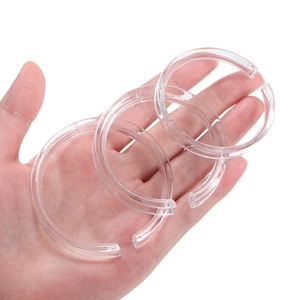 Three clear acrylic C-shape display rings for jewelry and bracelets on a white background