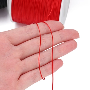 Detailed close-up of 0.8mm red elastic cord being stretched for DIY jewelry making