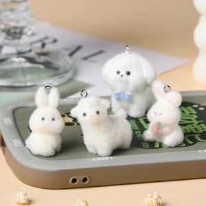 Macro detail of cute white flocked animal charms on phone case with metal hooks