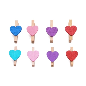 Dettaglio di otto mollette in legno colorate a forma di cuore per decorazioni DIY