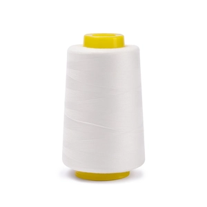 Macro view of white 402 polyester sewing thread on yellow plastic core spool