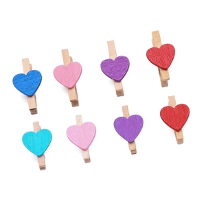 Dettaglio di mollette in legno con cuori colorati per decorazione foto e muro fai da te