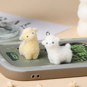 Close-up of cute flocked sheep pendants in white and yellow with metal hooks