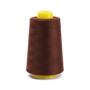 Macro detail of dark brown polyester sewing thread wound on a bright yellow plastic core
