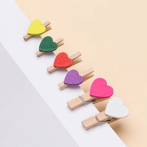 Dettaglio di 6 mollette in legno a forma di cuore colorato per decorazione foto