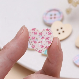 Macro shot of heart-shaped wooden button with pink floral print for DIY crafts