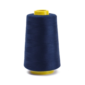 Detail of high-speed polyester sewing thread roll in navy blue with yellow plastic cone