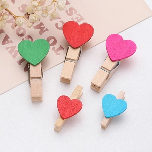 Dettaglio di mollette in legno colorate a forma di cuore per decorazioni di foto e fai da te