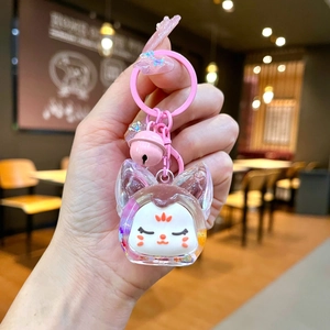 Gros plan d'un porte-clés chat rose avec une coque transparente et une petite clochette