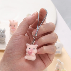 Close-up of cute pink flocked pig charm with heart for DIY phone case and bag decor