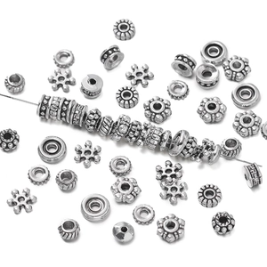 Detalle macro de cuentas espaciadoras de aleación de plata antigua para crear joyería DIY