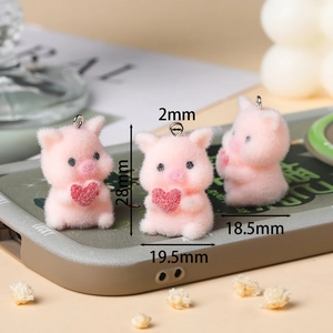 Detail of pink flocked pig charm with red heart showing 28mm size and fuzzy texture