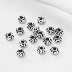 Cuentas planas de plata tibetana en forma de rueda con textura granulada y bordes trenzados