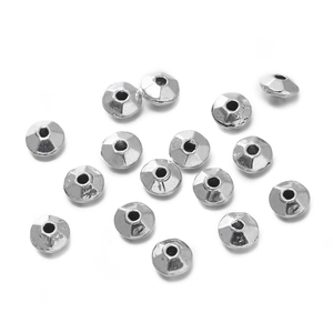 Vista macro de cuentas espaciadoras facetadas en aleación de zinc plateado para joyería DIY