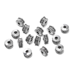 Detalle de cuentas espaciadoras de plata con grabados geométricos para creación de joyas DIY