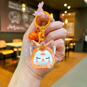 Détail d'un porte-clés renard mignon en résine avec paillettes et grelot assorti