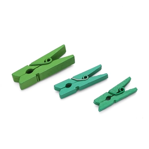 Macro view of three different sized green wooden photo clips with metal springs
