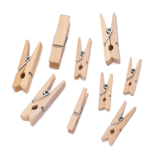 Scattered natural wooden clothespins with metal springs on a clean white background