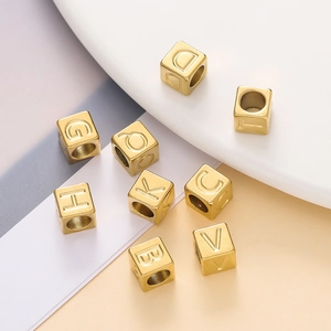 Macro shot of gold cube alphabet beads for DIY jewelry with engraved letters