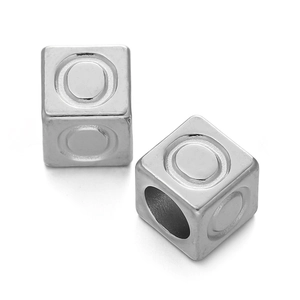 Close-up of polished stainless steel cube beads with circular grooves for DIY jewelry