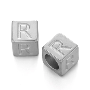 Macro detail of 7mm stainless steel cube beads with R letter engraving for DIY jewelry